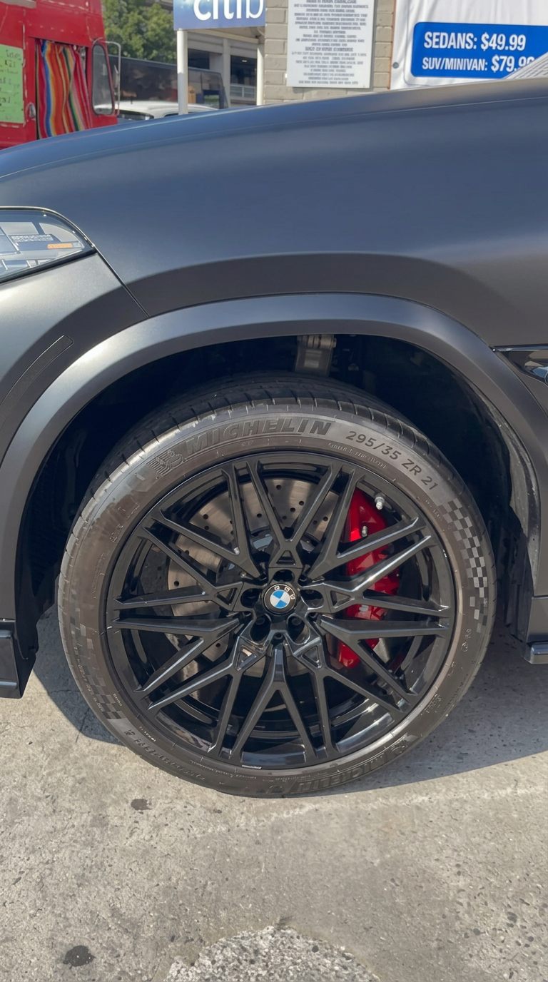 Gloss black BMW wheel with red caliper after deep rim cleaning